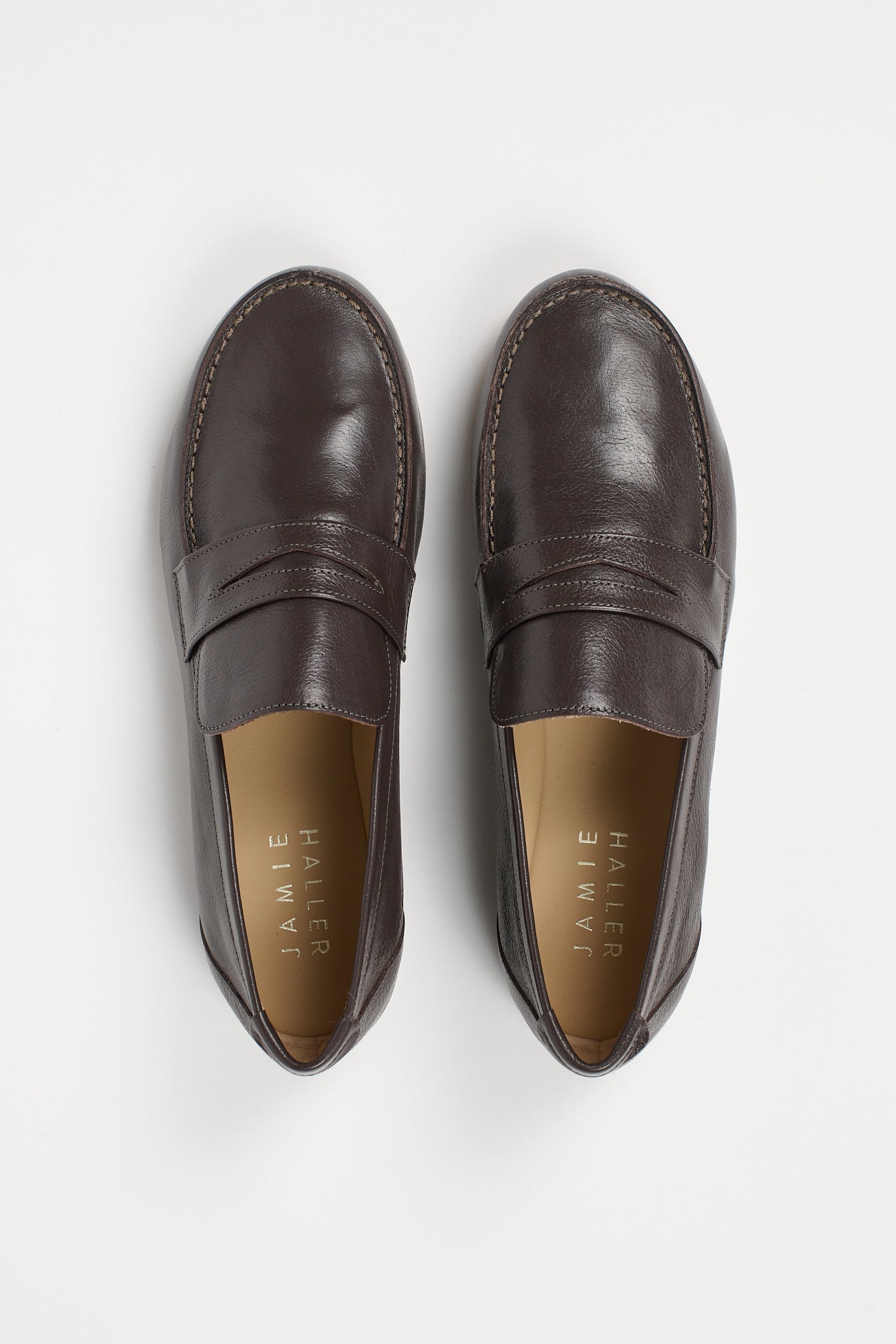 pair of grey penny loafers on a white background