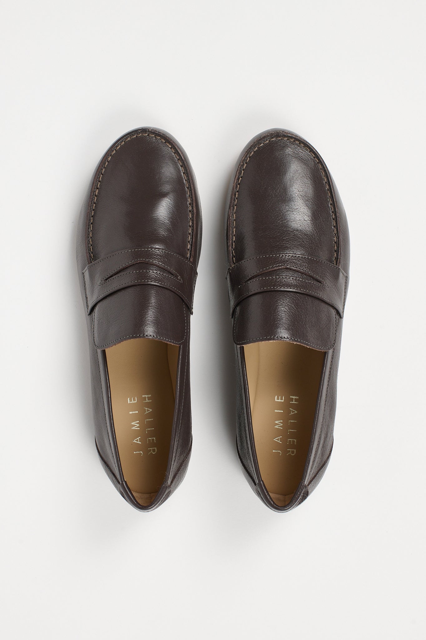 pair of grey penny loafers on a white background