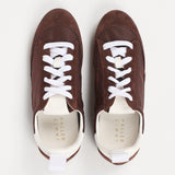 Pair of brown sneakers with white laces on a white background