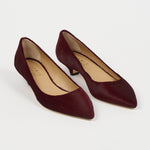 A pair of pointed-toe low-heel pumps in deep burgundy suede, shown from a high-angle view on a clean white background. The brand name 'Jamie Haller' is visible on the beige insoles.