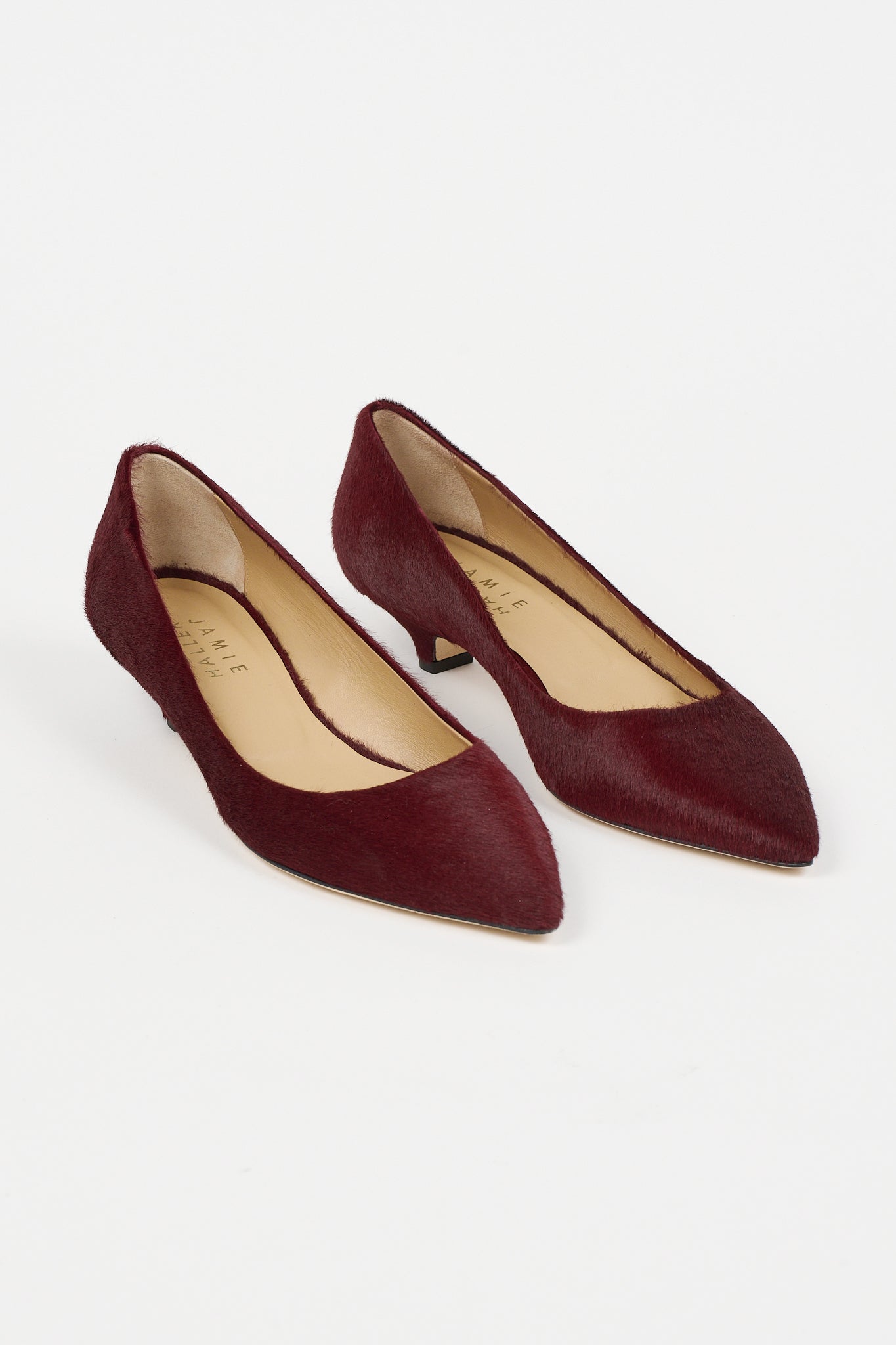 Jamie Haller claret ponyhair pointed kitten heel pumps with slim heels, almond shaped toes, and leather soles, shown as a pair on a white background
