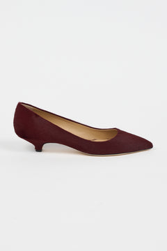 A single black woven Mary Jane flat shoe with a braided strap and pointed toe, shown in profile against a light gray background.