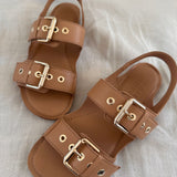 The Double Buckle Sandal in Bare on Bed 1