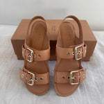 The Double Buckle Sandal in Bare on Bed Angled Down