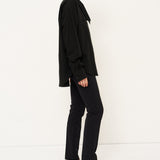 Person wearing a black outfit with a white background
