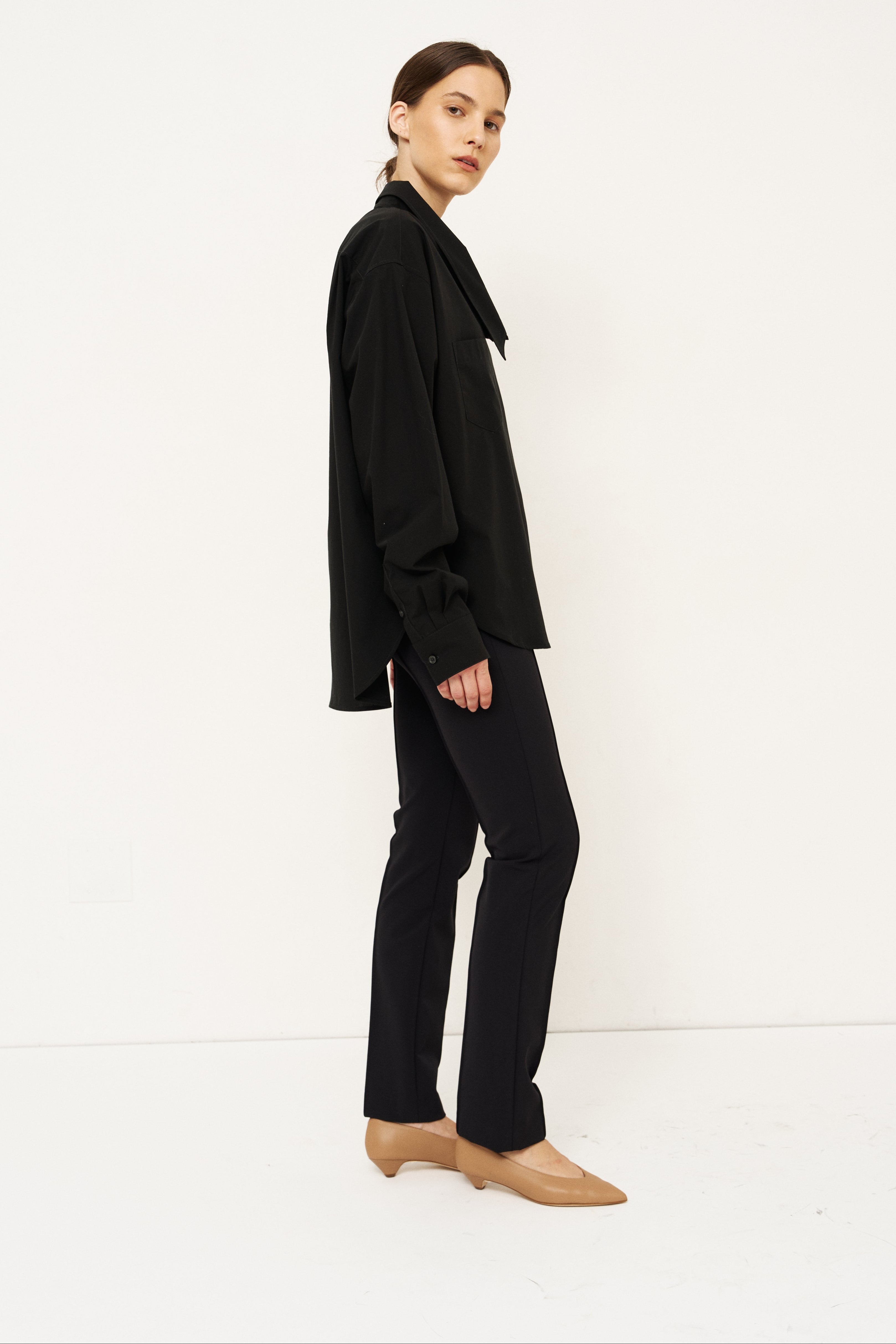 Person wearing a black outfit with a white background