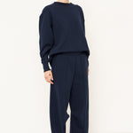 woman in navy tracksuit against a white background