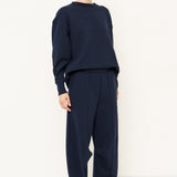 woman in navy tracksuit against a white background