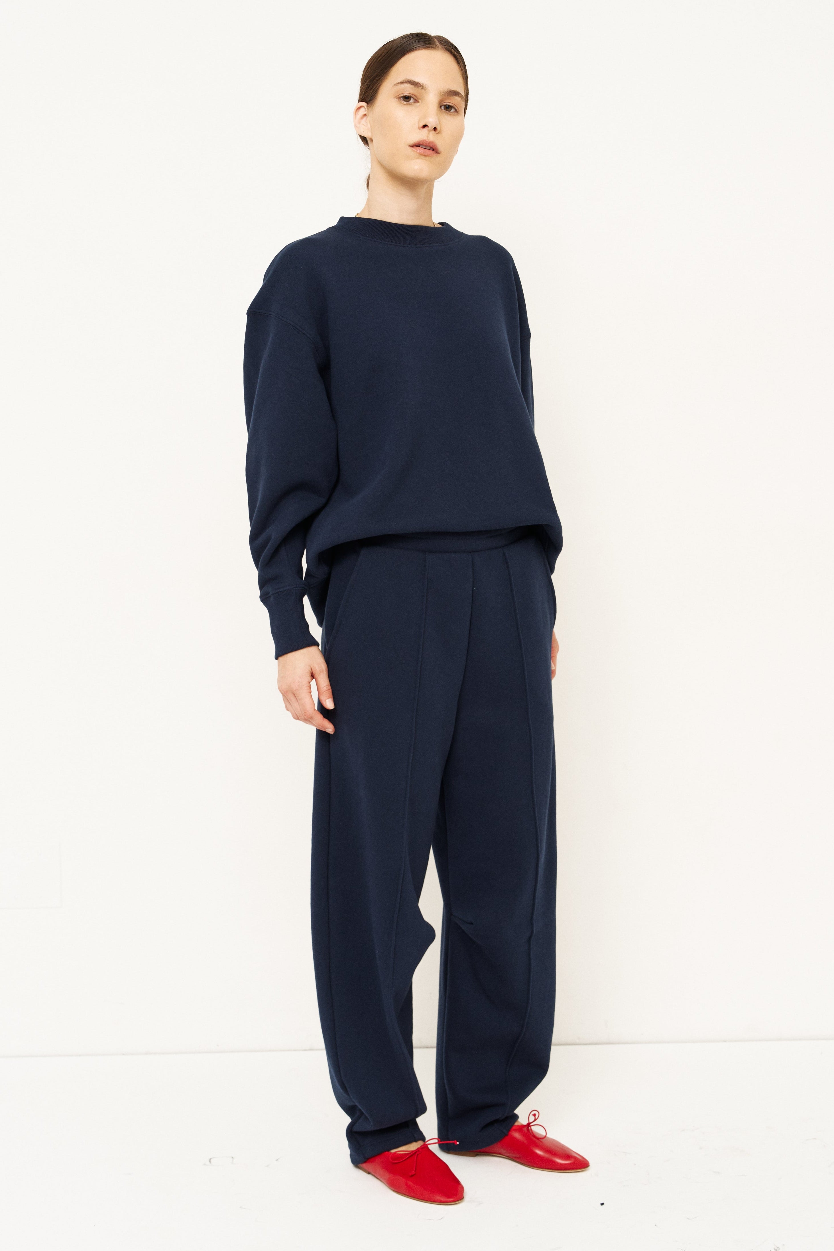 woman in navy tracksuit against a white background