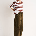 Person wearing a striped shirt and wide-leg pants on a white background