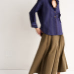 Person wearing a blue shirt and brown skirt on a white background