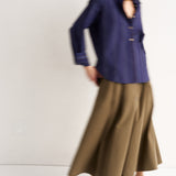 Person wearing a blue shirt and brown skirt on a white background