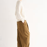 Person wearing a white shirt and brown pants on a white background