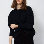 woman in all black with a white background