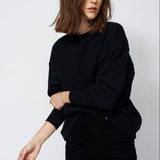 woman in all black with a white background
