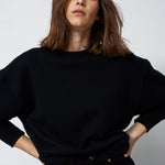 woman in all black with e white backgournf