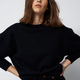 woman in all black with e white backgournf