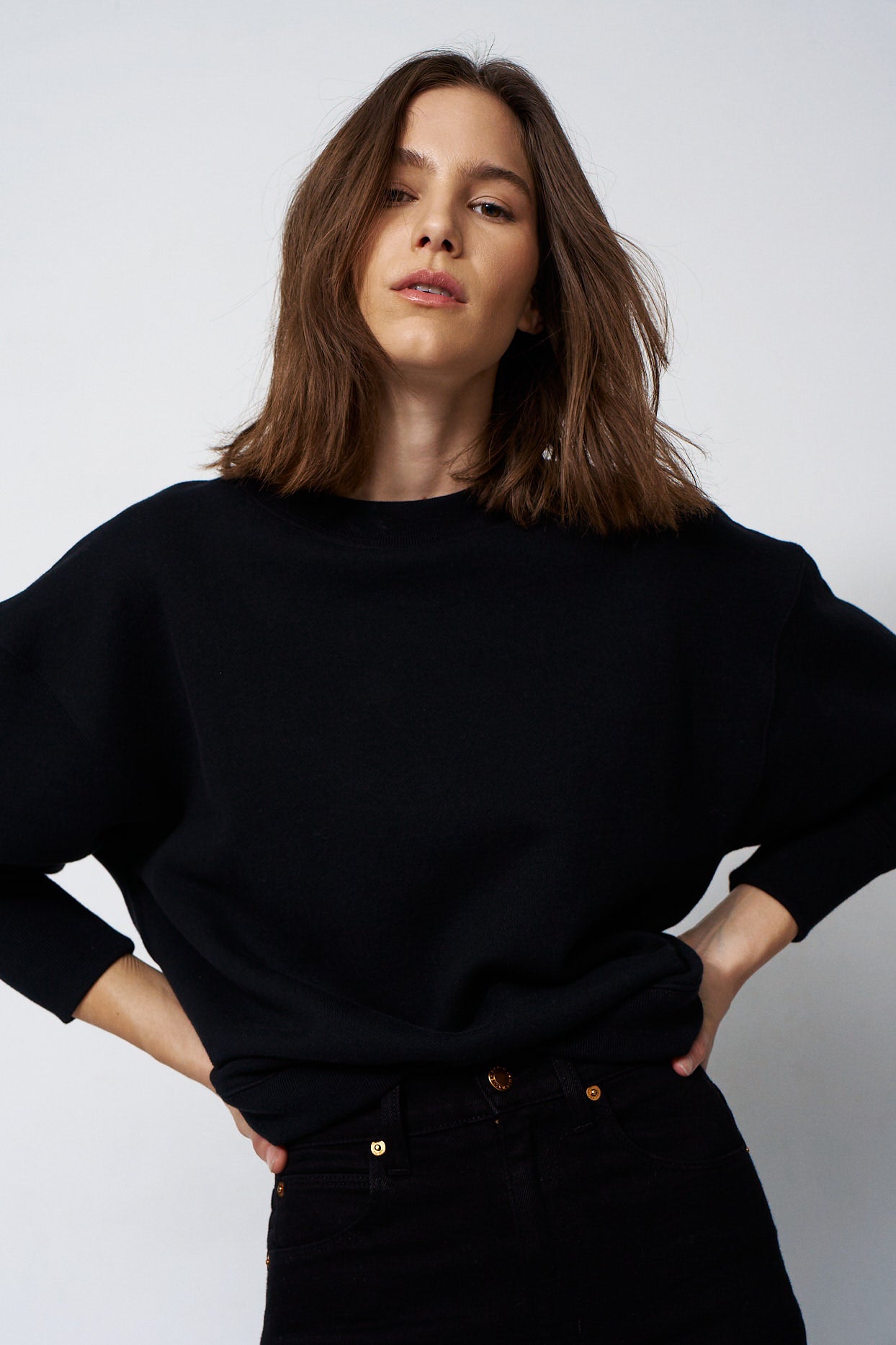 woman in all black with a white backgournd