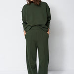 model standing in a sweatsuit in front of a white wall