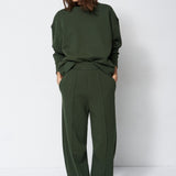 model standing in a sweatsuit in front of a white wall