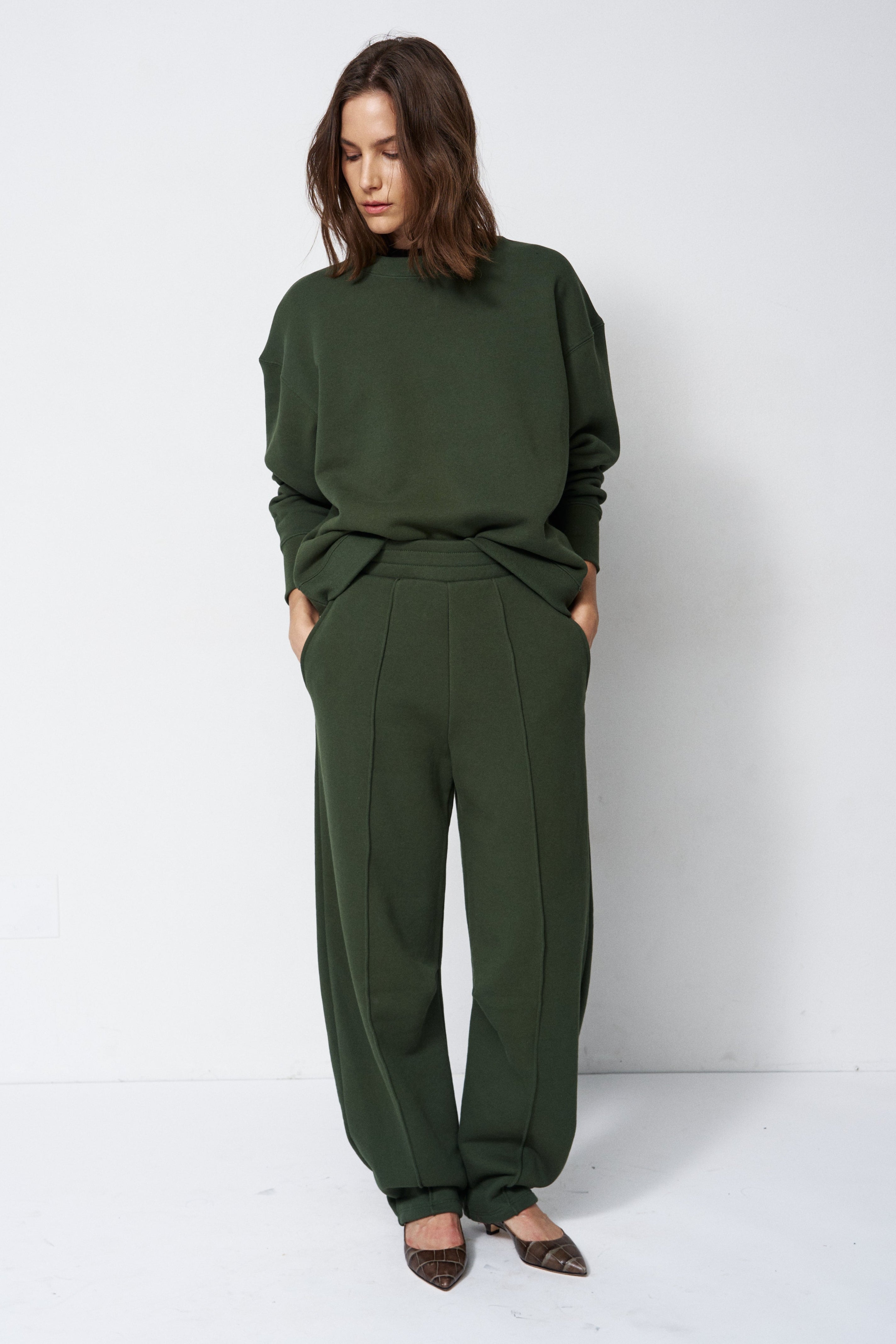 model standing in a sweatsuit in front of a white wall