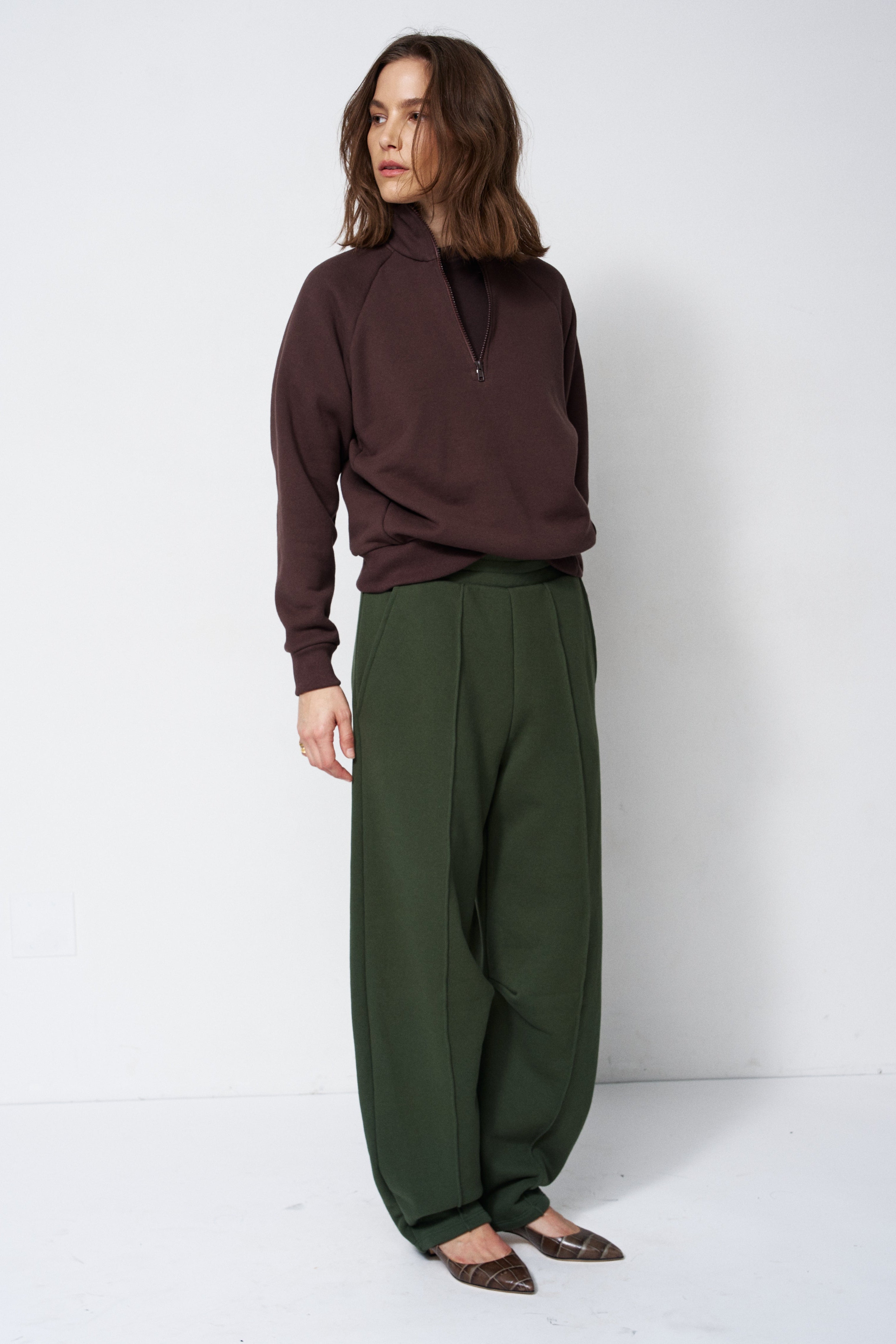 model standing in a sweatsuit in front of a white wall