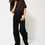 Person wearing a dark brown shirt and black pants on a white background