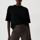 woman in black tee in front of a white background