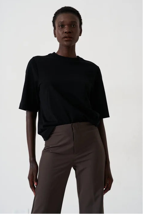 woman in black tee in front of a white background