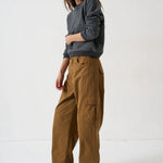 Woman wearing Jamie Haller deep grey sweatshirt, brown cargo pants, and red sneakers.