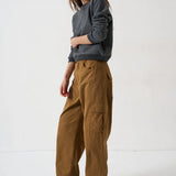 Woman wearing Jamie Haller deep grey sweatshirt, brown cargo pants, and red sneakers.
