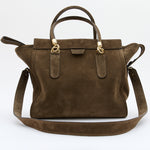 An olive suede handbag with gold-tone hardware, featuring dual top handles and a detachable shoulder strap, photographed against a clean white background.