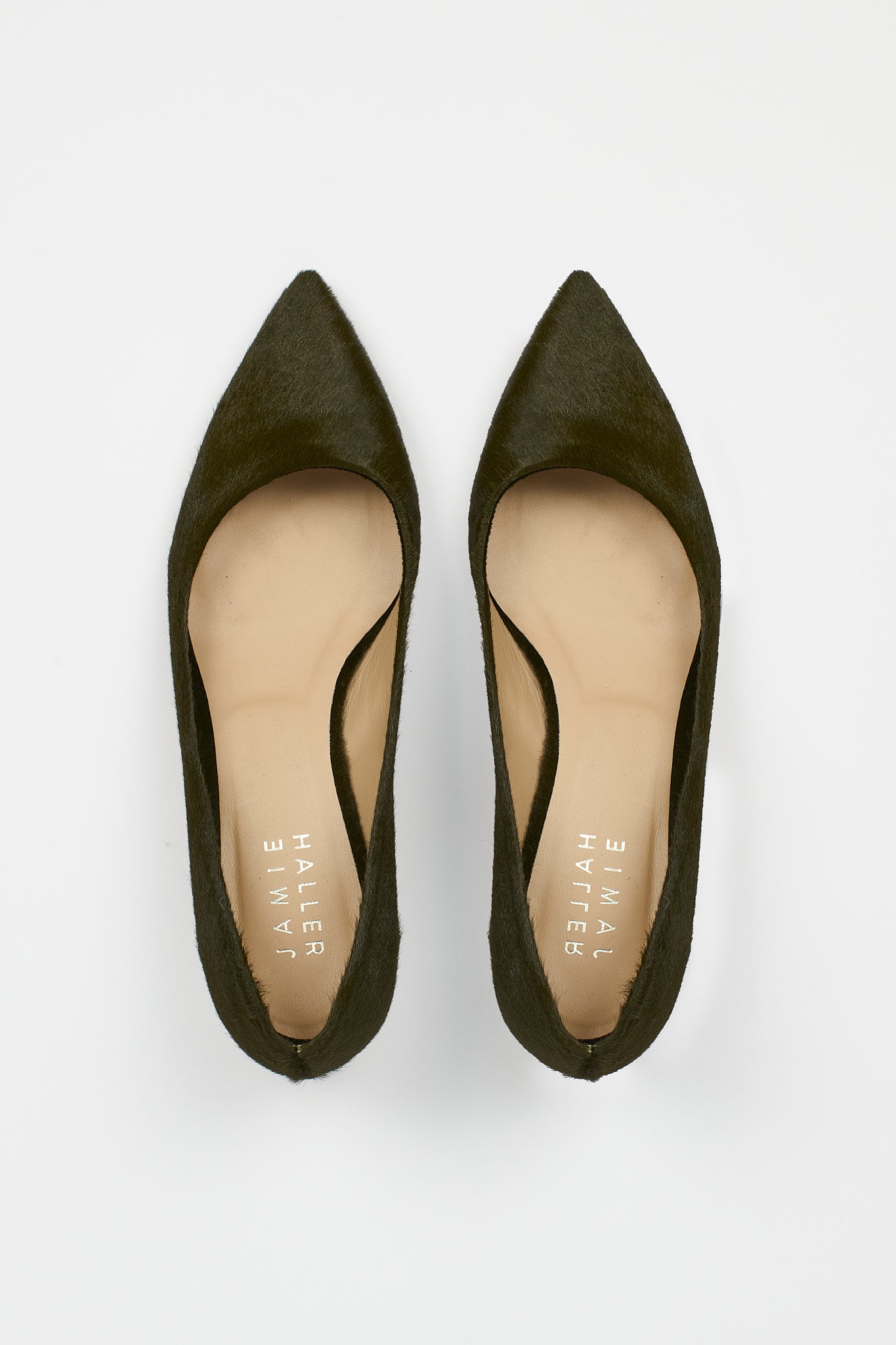 A pair of pointed-toe flats in dark olive green suede, shown from a top-down view on a light gray background. The insoles are beige with the brand name 'Jamie Haller' printed vertically.