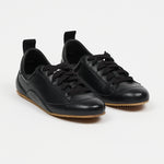 black leather sneakers set in front of white wall
