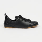 one black leather sneaker in front of white background