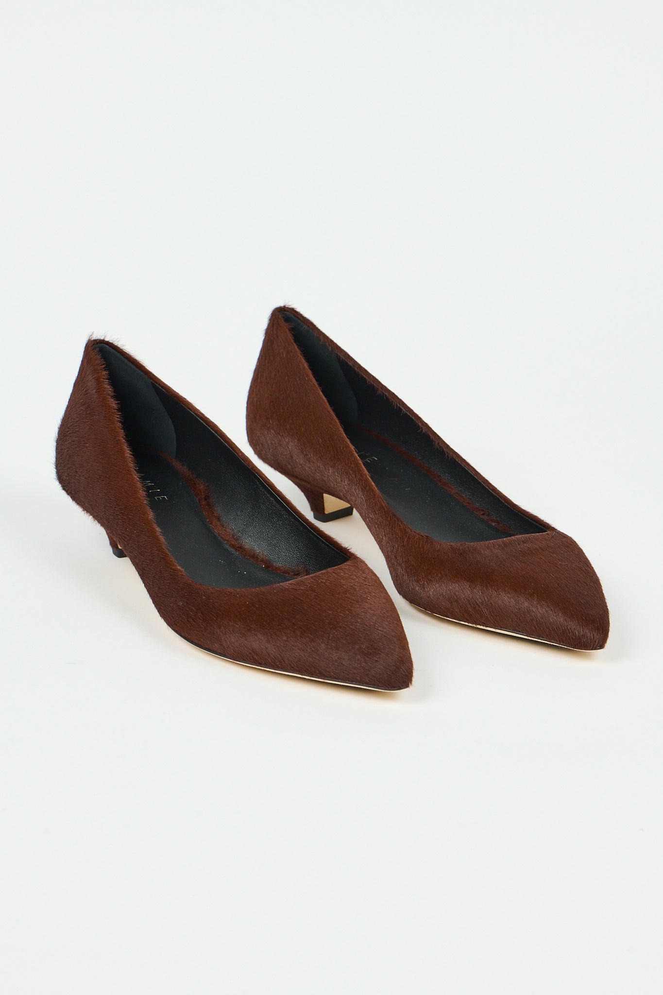 A pair of women's pointed-toe pumps in dark brown textured suede or hair-on-hide, shown on a clean white background.