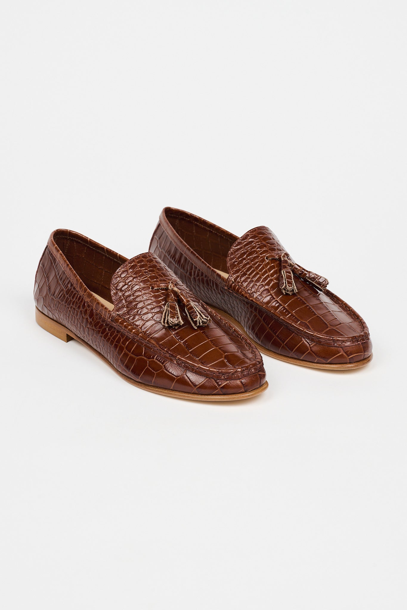 brown loafers with white sole on a white background