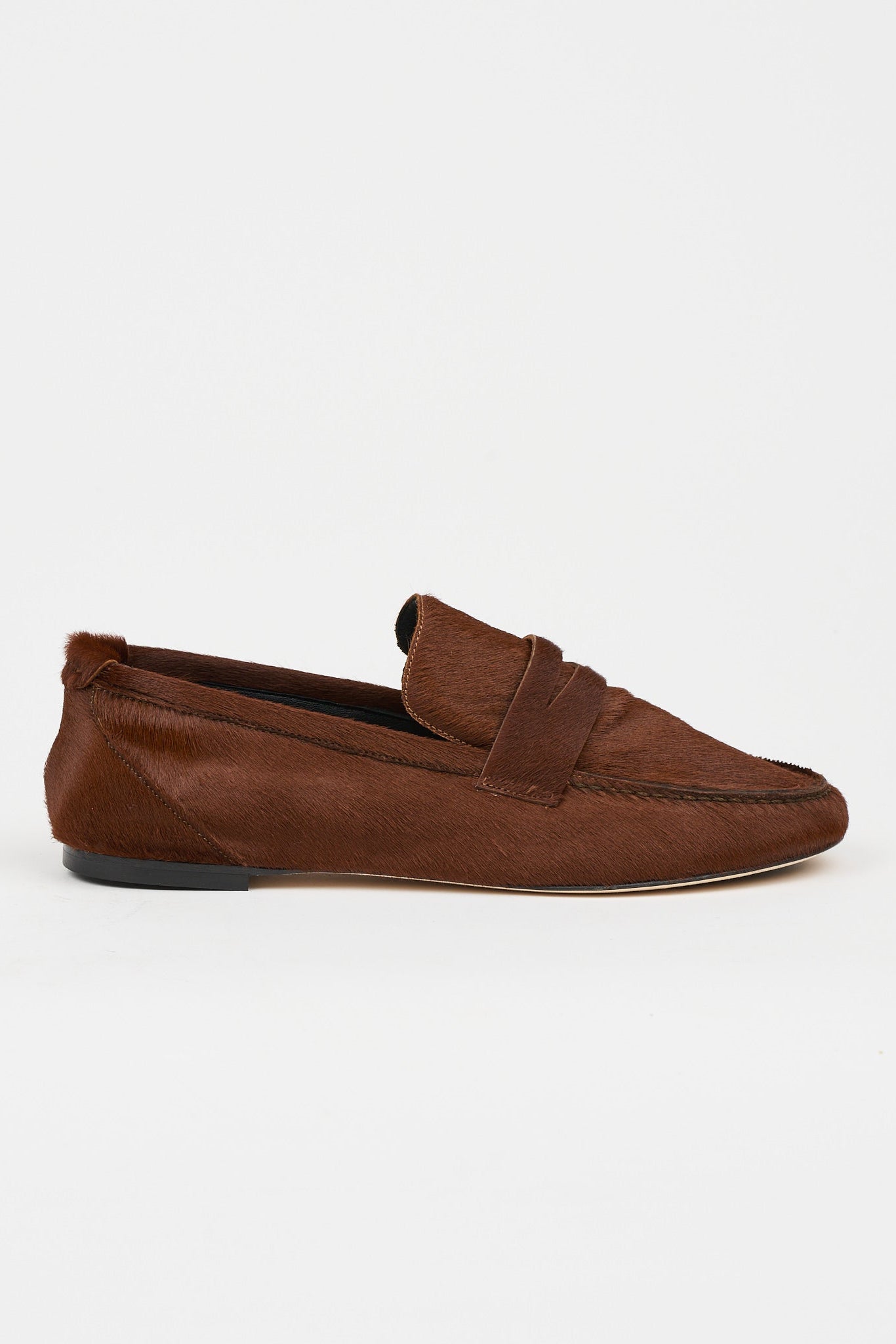 Side view of Jamie Haller rosewood brown ponyhair penny loafer with a leather sole, low profile, and distinctive strap detail on a white background