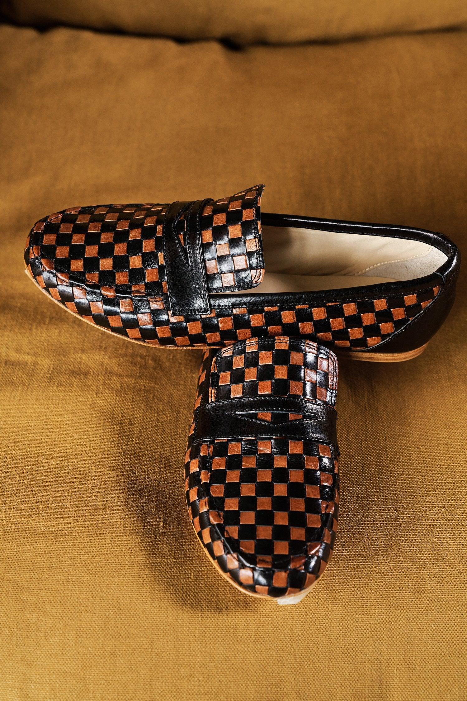 Black and Brown Woven Loafer Flat View on Top of Green Couch