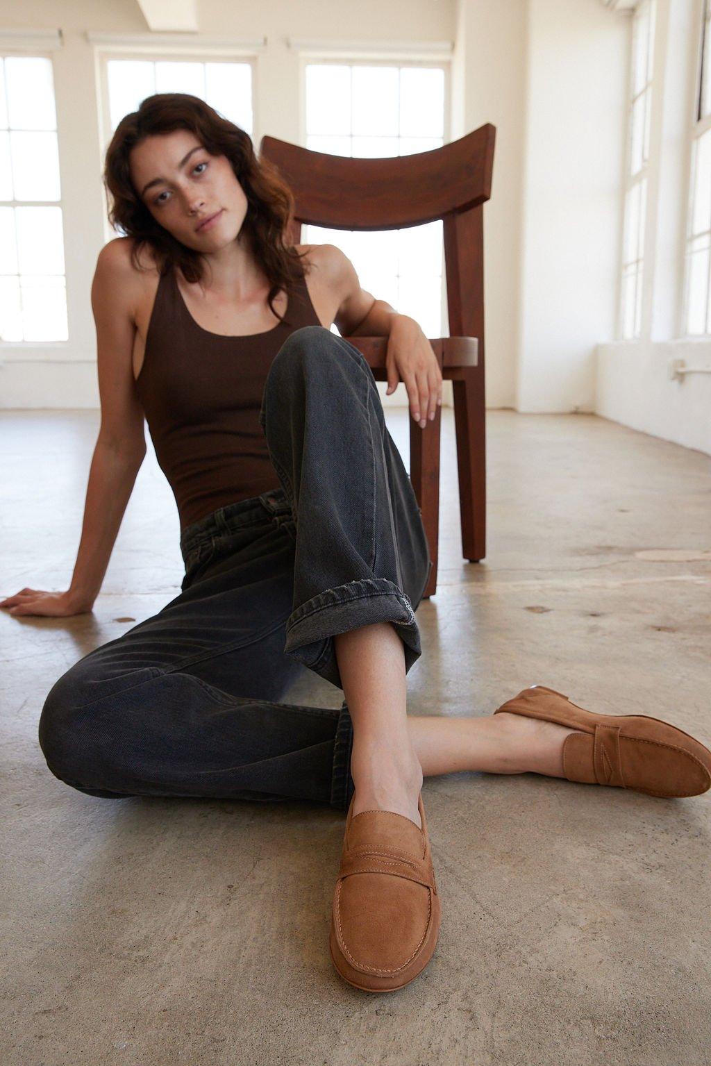 The Penny Loafer in Clove Suede on Body Sitting on Floor 