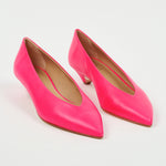 A pair of bright pink leather pointed-toe pumps with kitten heels, displayed on a clean white background.